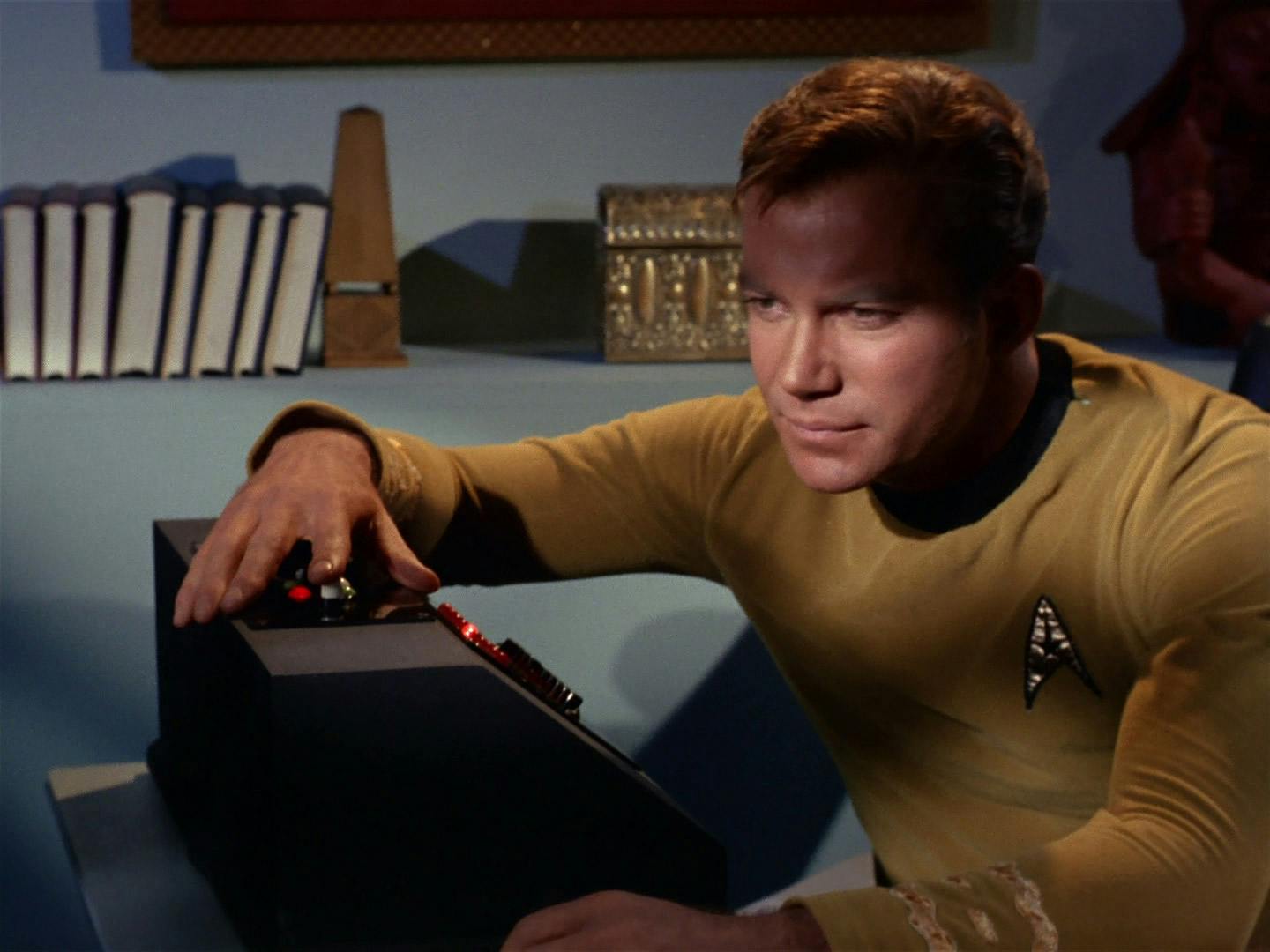 In his quarters, Kirk records his captain's log while resting his arm on the top of his computer console in 'Tomorrow is Yesterday'