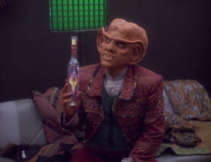 Quark raises a bottle while seated in his quarters in 'Prophet Motive'