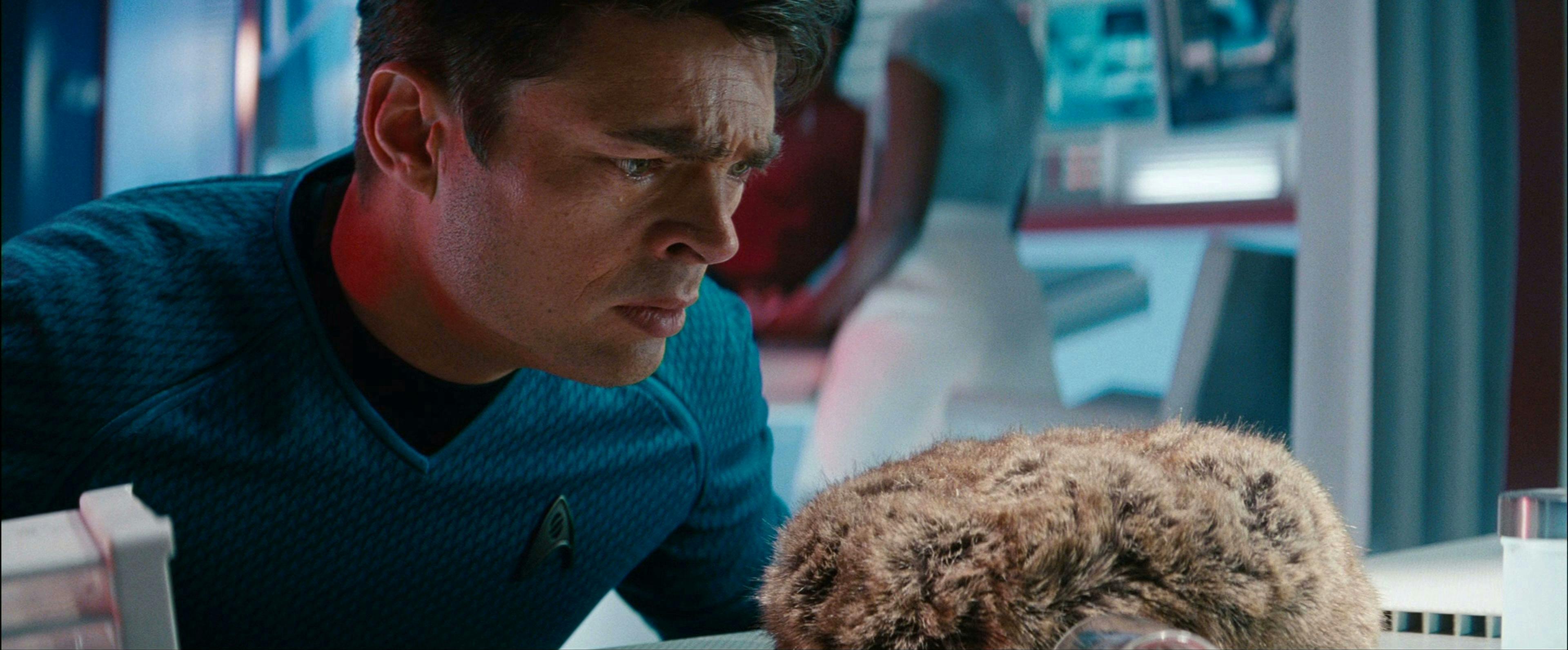 In Sickbay, a distressed Leonard McCoy looks up close-up at a Tribble in front of him in Star Trek Into Darkness