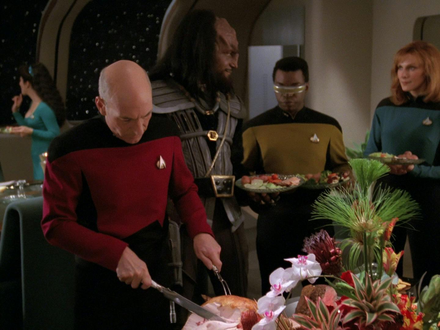 Jean-Luc Picard prepares a meal and carves a turkey for his senior crew along with Kurn in the Enterprise's Observation Lounge in 'Sins of the Father'