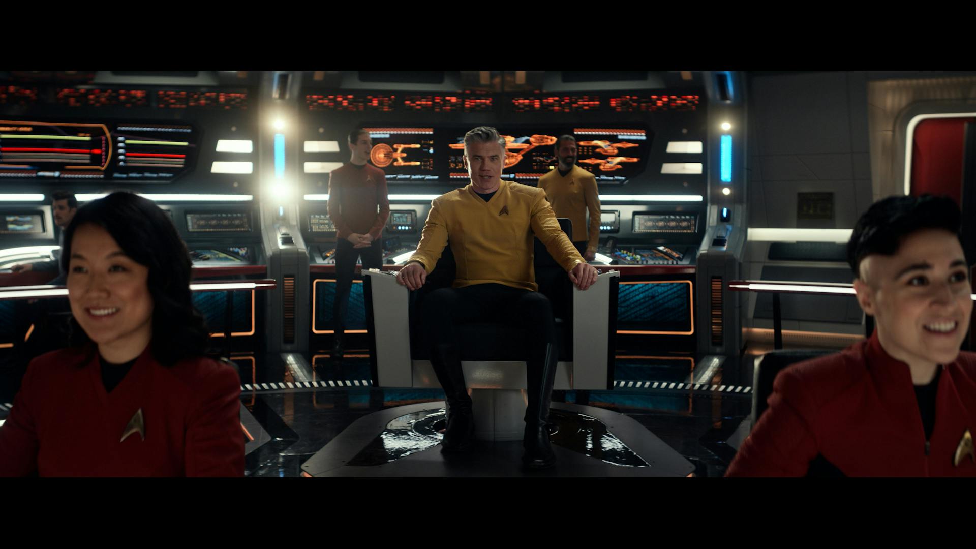 Pike sits in the captain's chair with Jenna Mitchell at nav and Erica Ortegas at the helm on the bridge of the U.S.S. Enterprise in 'Subspace Rhapsody'