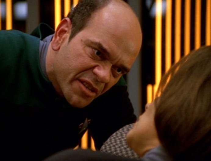 Altering his personality subroutine, The Doctor leans over B'Elanna in Sickbay in a menacing fashion in 'Darkling'