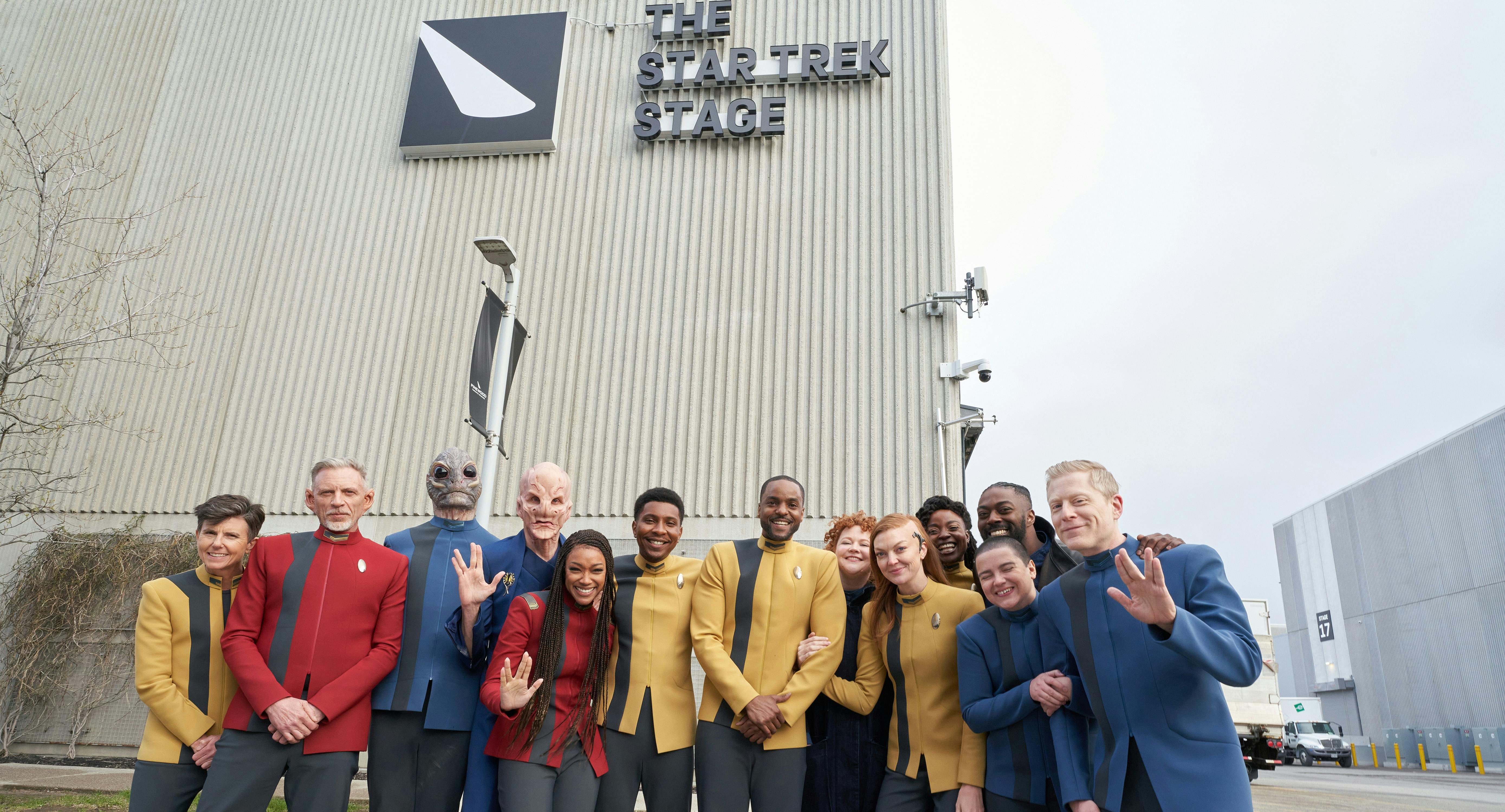 Cast of Star Trek: Discovery in costume stand in front of the newly renamed Star Trek stage in Pinewood Toronto