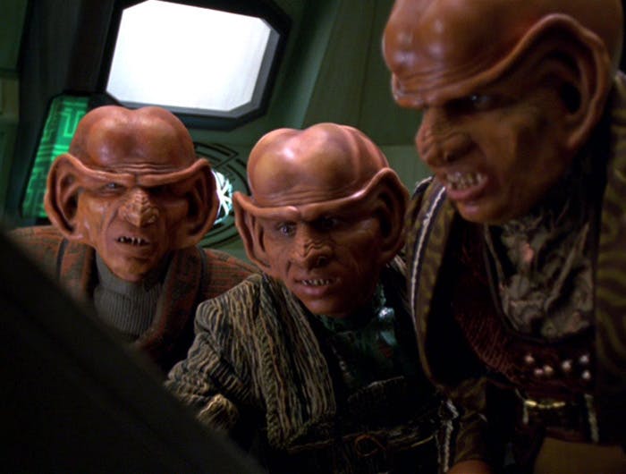 On their ship, three Ferengi crowd around a control panel in 'Inside Man'