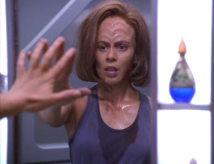 A sweaty and volatile B'Elanna Torres reaches in front of her and looks at her reflection in the mirror in 'Extreme Risk'