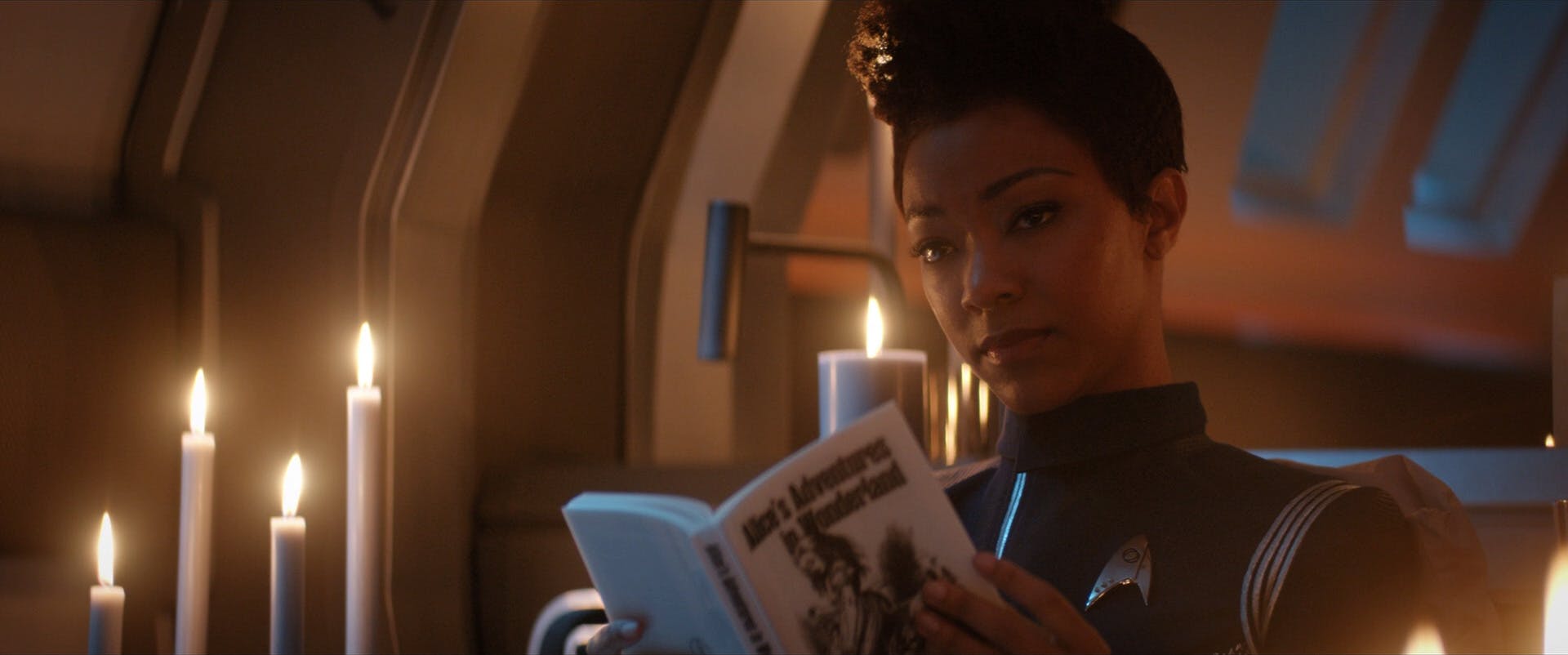 In her quarters, Michael Burnham reads a physical copy of Alice's Adventure in Wonderland in 'Brother'