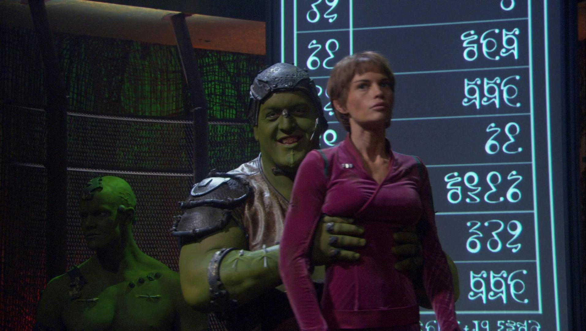 A member of the Orion Syndicate lifts T'Pol up as he attempts to auction her off as a slave in 'Borderland'