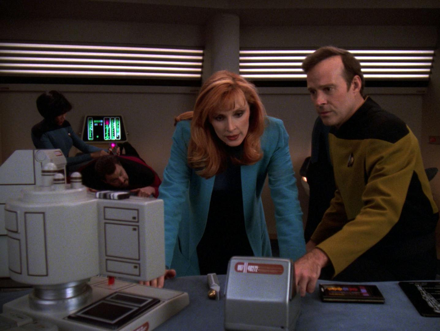 Dr. Crusher reviews Barclay's test results in Sickbay while Ogawa addresses the cactus needles in Riker's back in 'Genesis'