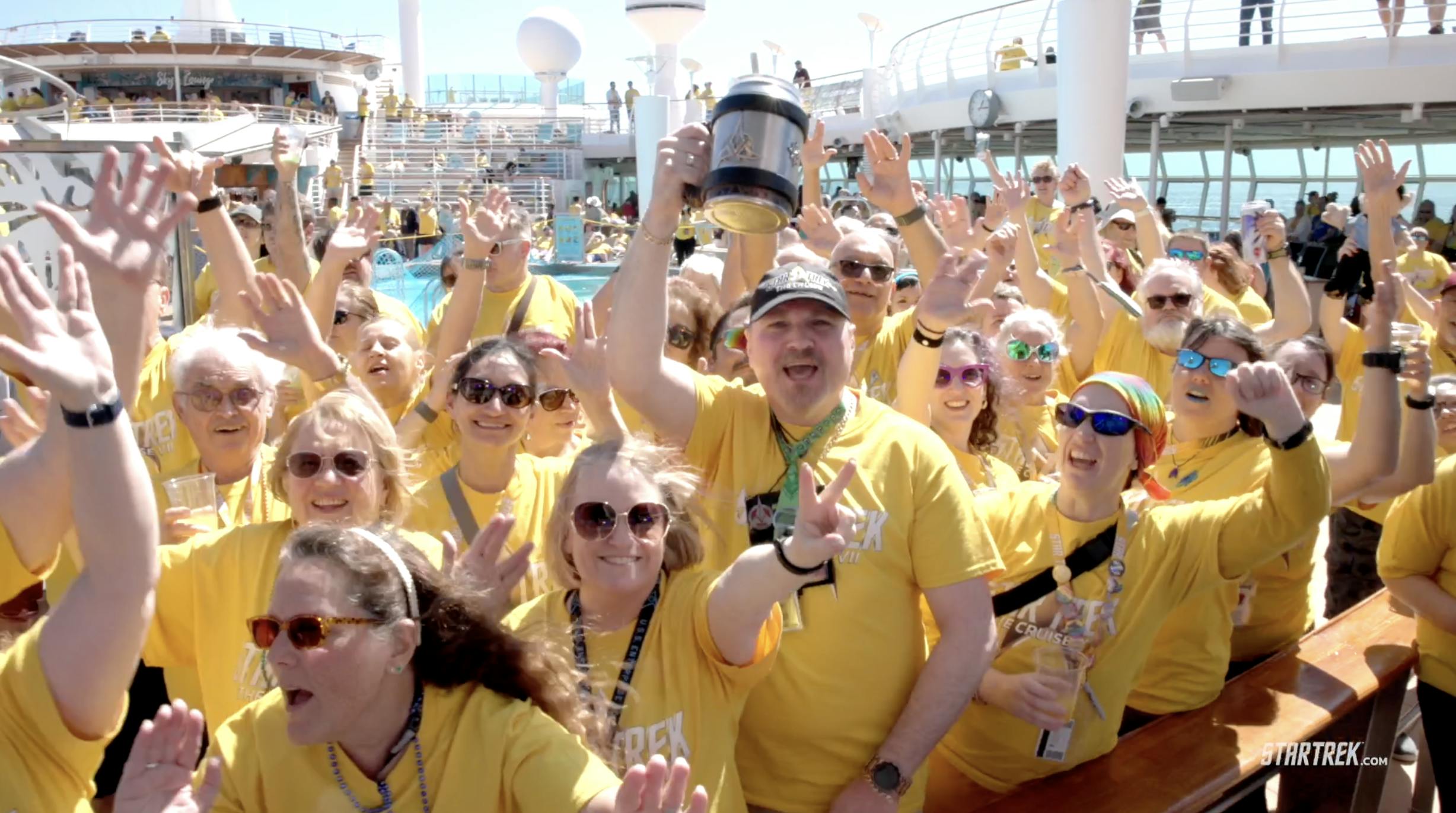 Star Trek: The Cruise VII: fans wearing yellow t-shirts celebrating on the pool deck and cheering