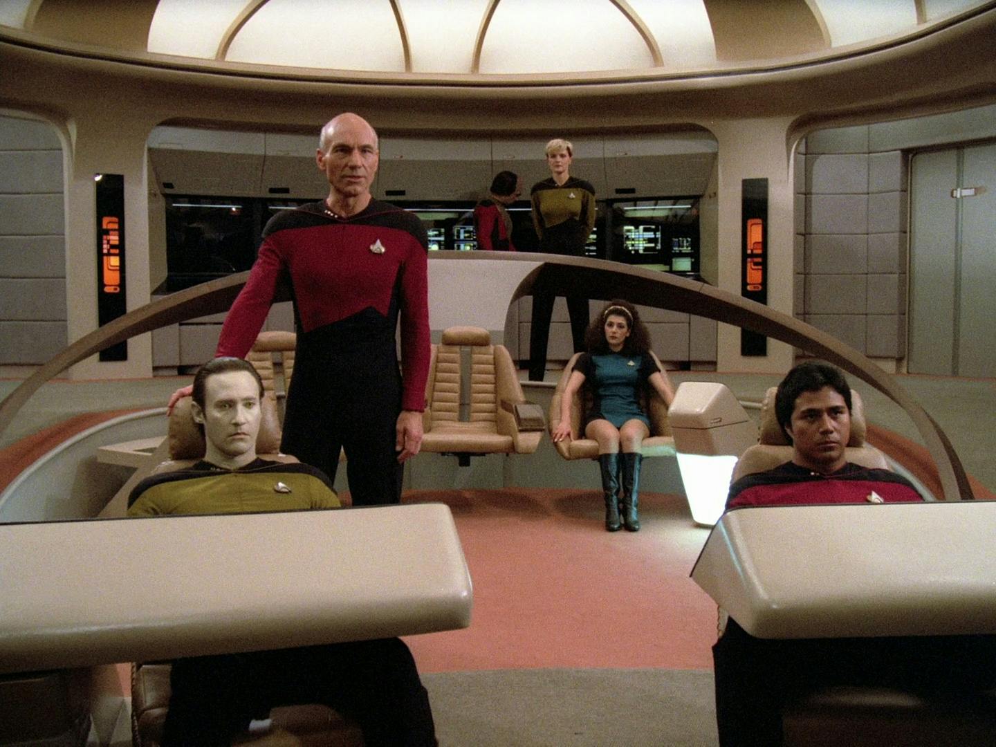 Captain Jean-Luc Picard walks onto the bridge of the Enterprise-D, stands behind Data, looking out to the viewscreen in 'Encounter at Farpoint'