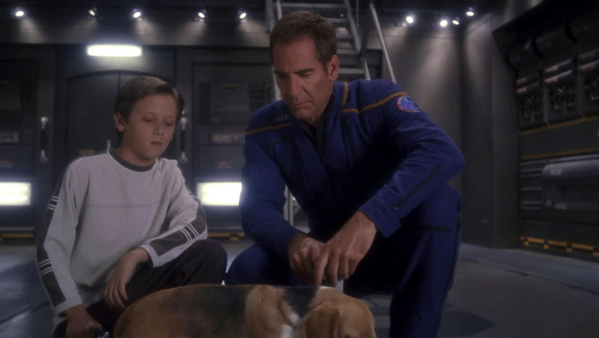 Archer crouches down besides the sim child of Trip Tucker as they both look over towards Porthos in 'Similitude'