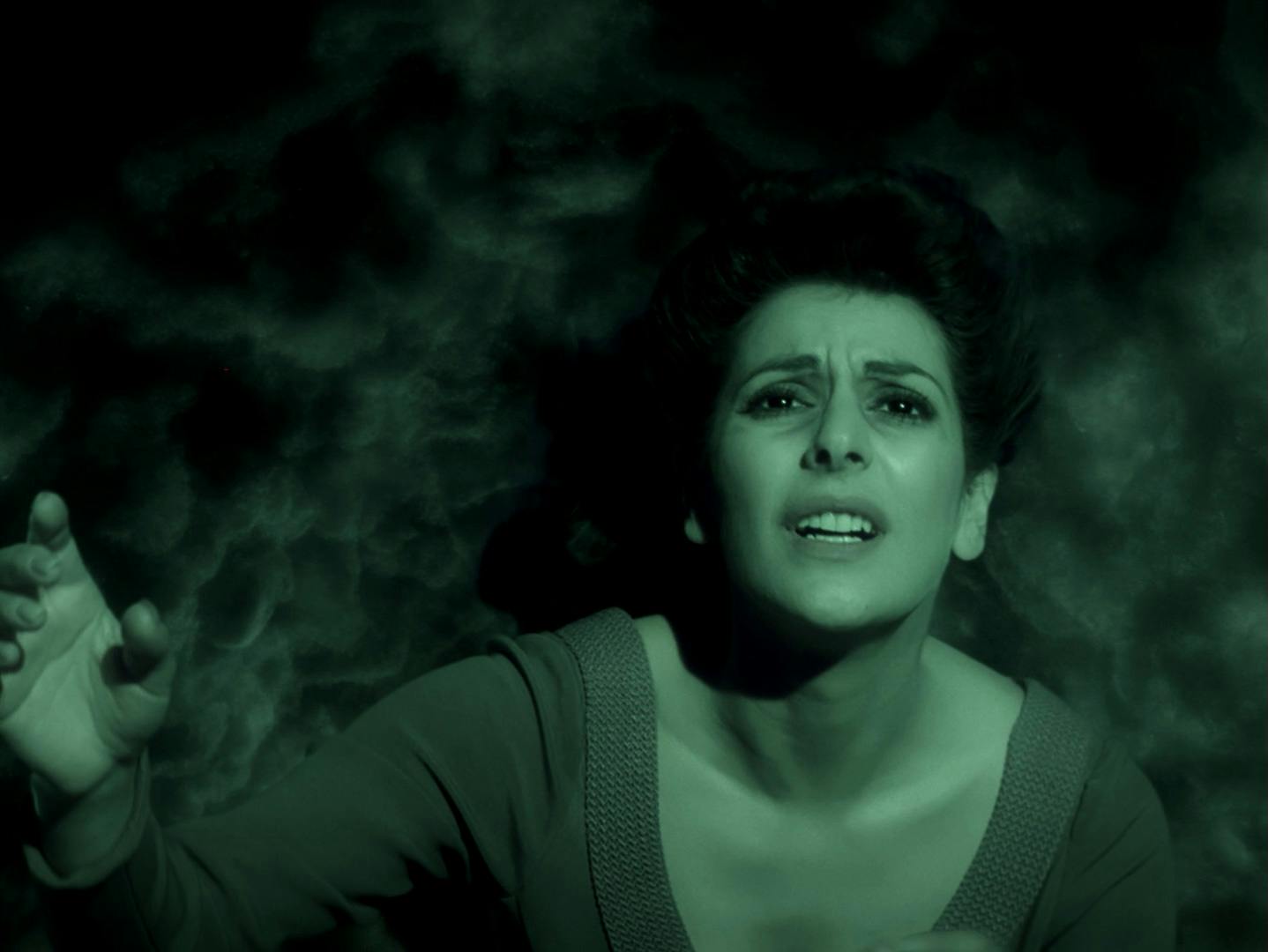 Deanna Troi distorts her face in pain and anguish as she looks above her towards an unknown entity in 'Night Terrors'