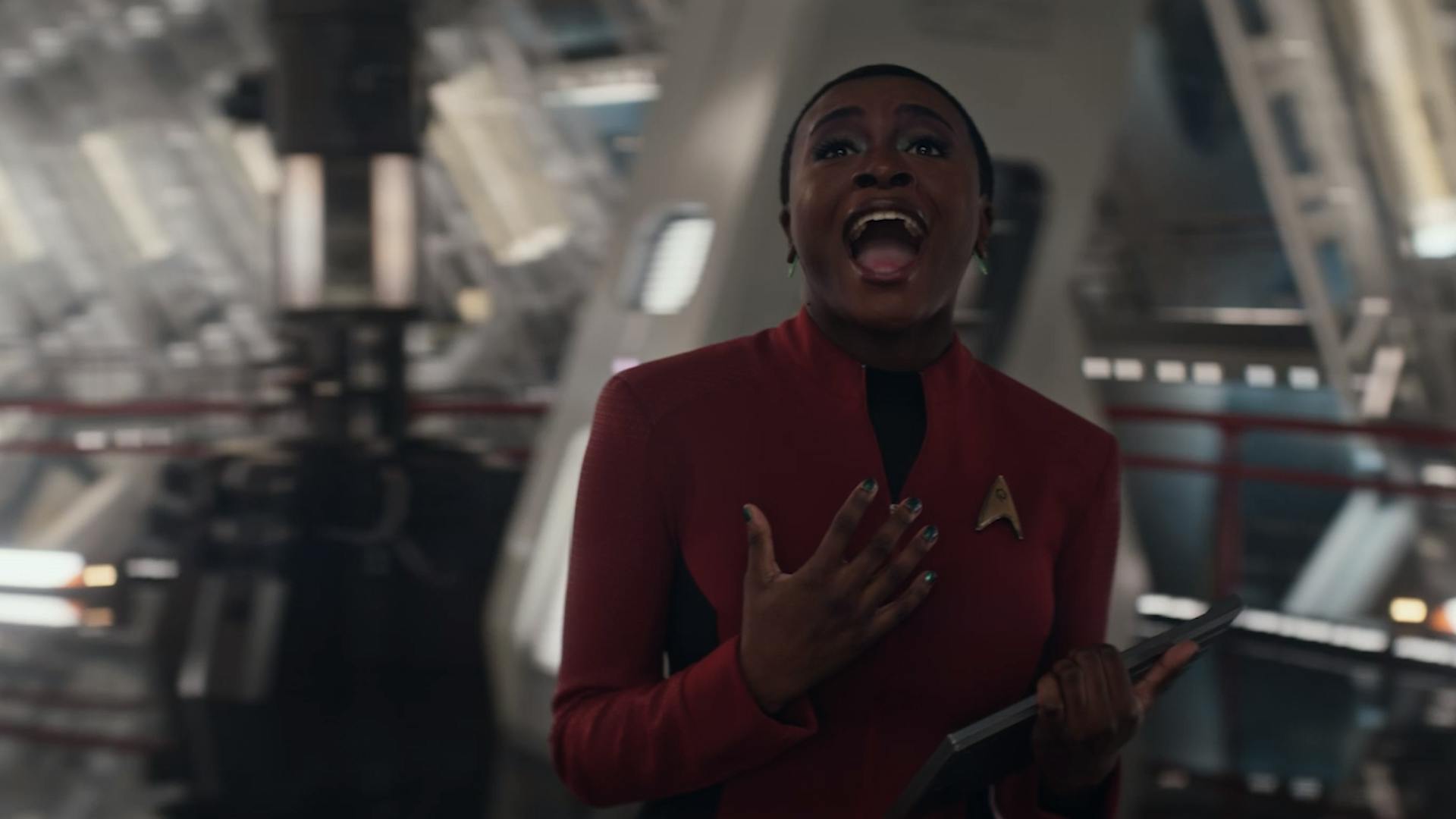 While holding a PADD in Engineering, Uhura is overcome by song in 'Subspace Rhapsody'