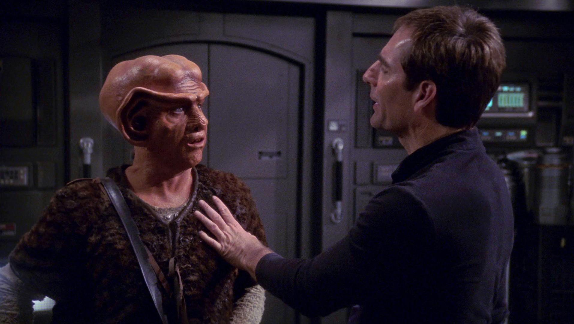 Aboard the Enterprise, Archer facing the Ferengi Krem places his palm on his shoulder in 'Acquisition'