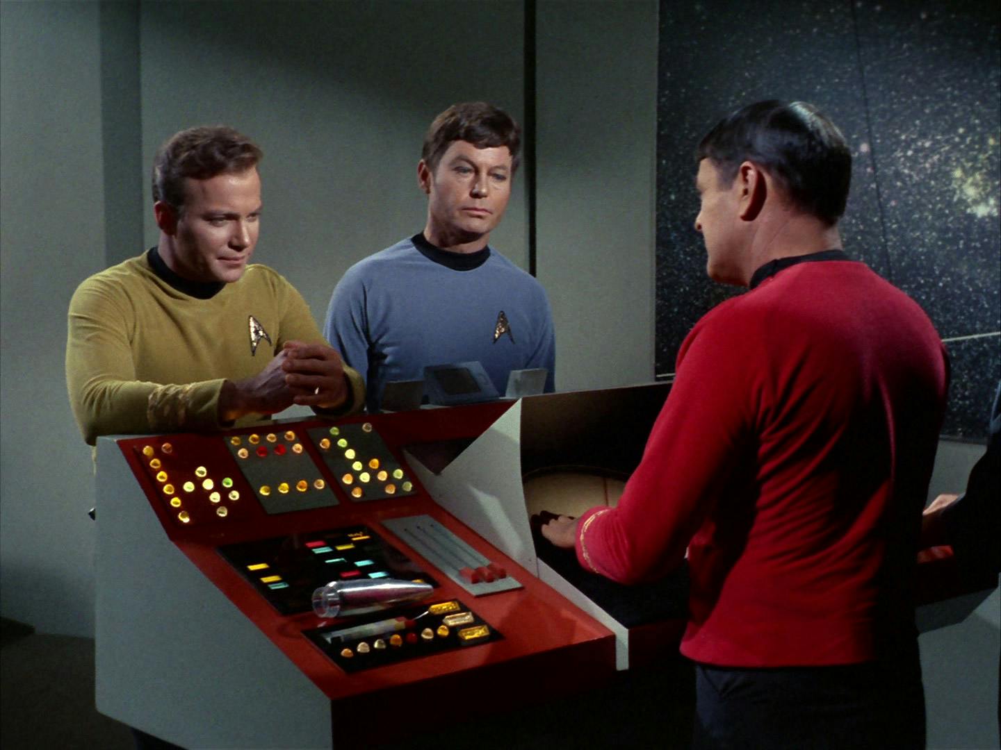 James T. Kirk and Dr. Bones McCoy stand across from Scotty in the transporter room in 'Space Seed'