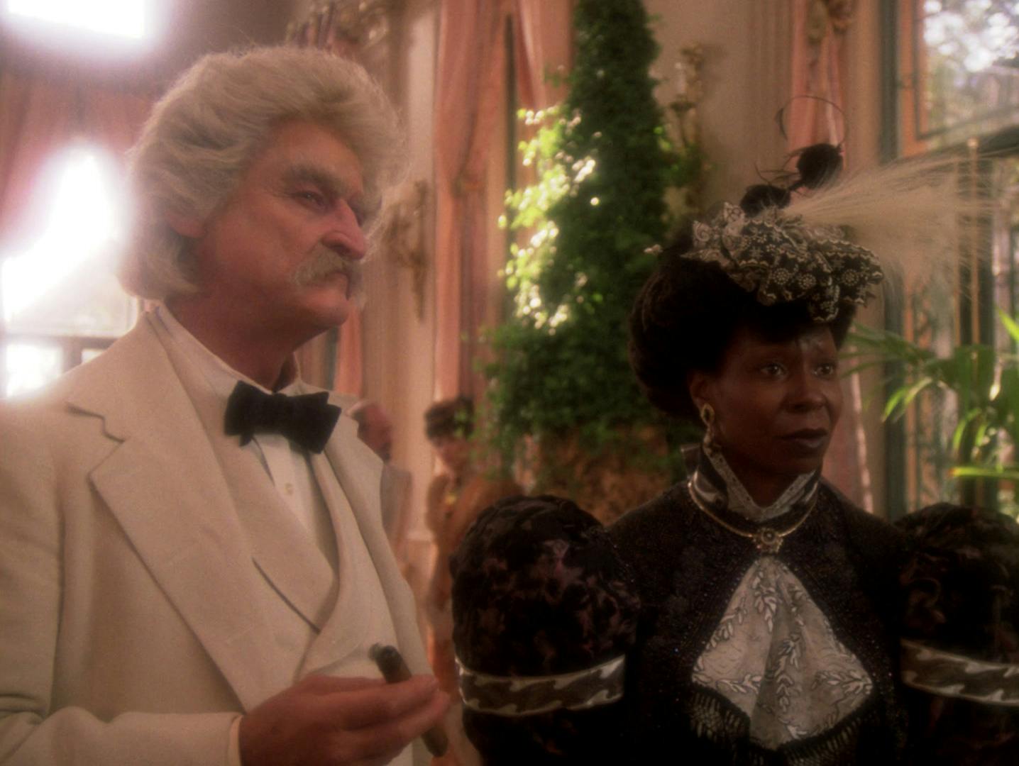 Samuel Clemens aka Mark Twain stands beside Guinan at a literary reception as they both stare intently at Data in 'Time's Arrow'