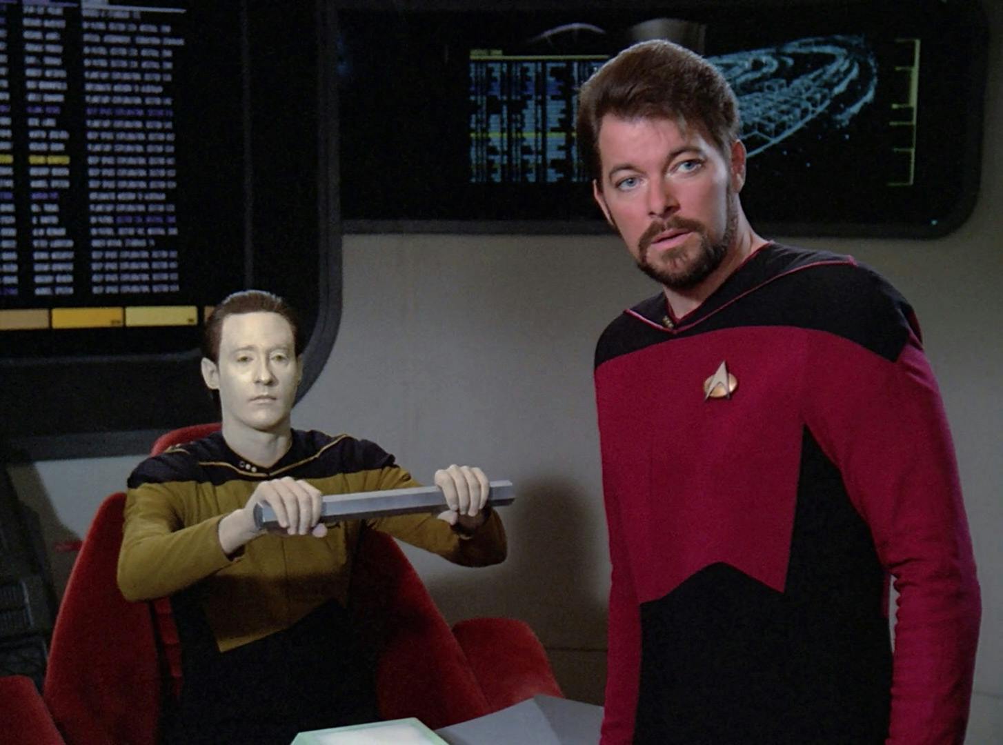 Riker stands before Data who lifts up a metal rod in 'The Measure of a Man'