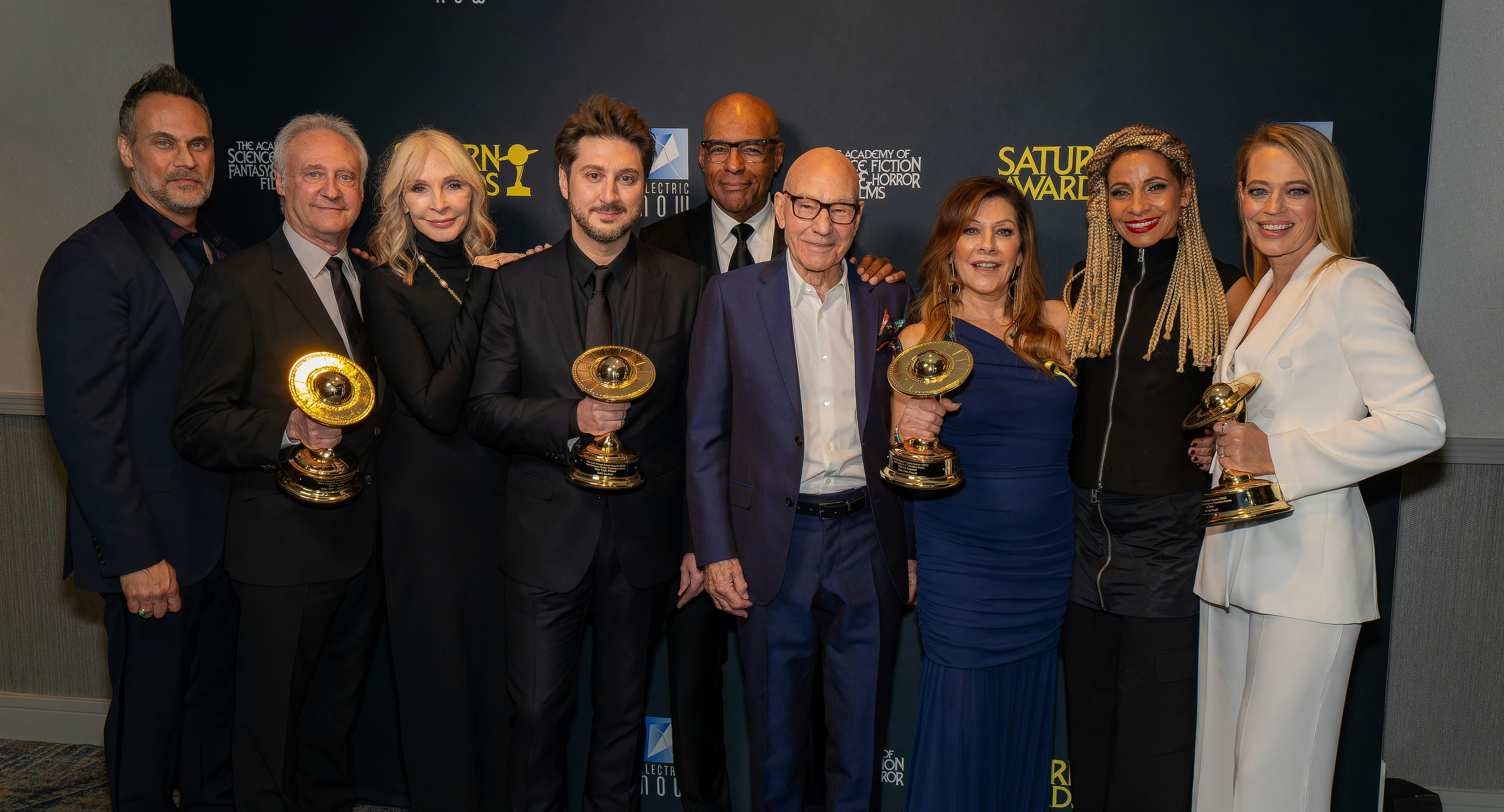 Todd Stashwick, Brent Spiner, Gates McFadden,  Terry Matalas, Michael Dorn, Patrick Stewart, Marina Sirtis, Michelle Hurd, and Jeri Ryan backstage at the Saturn Awards with their awards