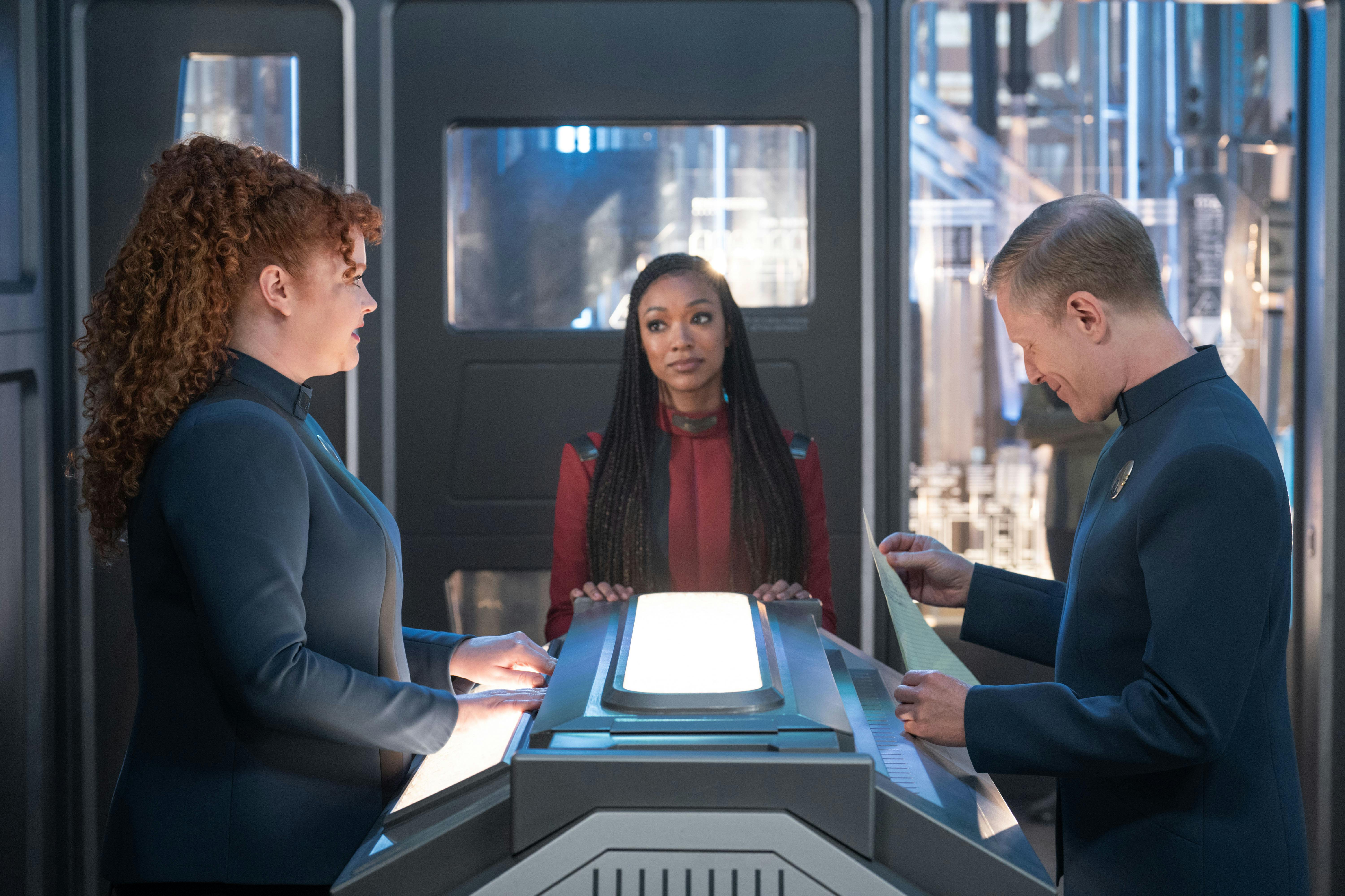 Burnham looks over at Tilly as Stamets analyzes a piece of paper with a list of names in 'Whistlespeak'