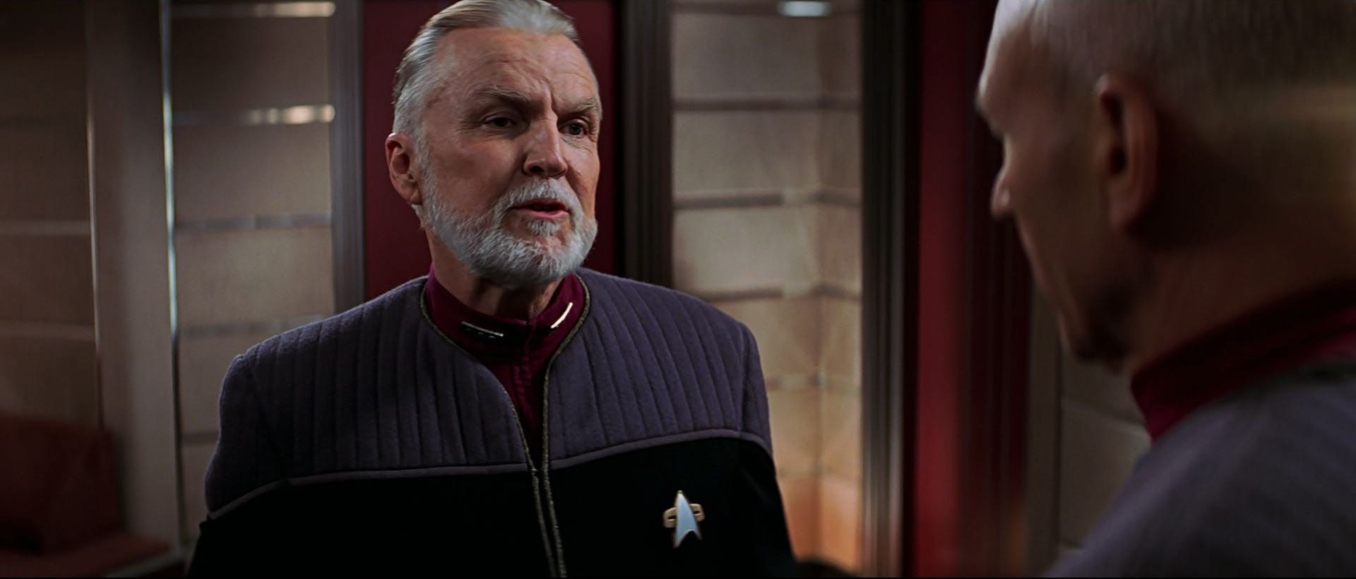 Admiral Dougherty approaches Picard in the captain's ready room in Star Trek: Insurrection