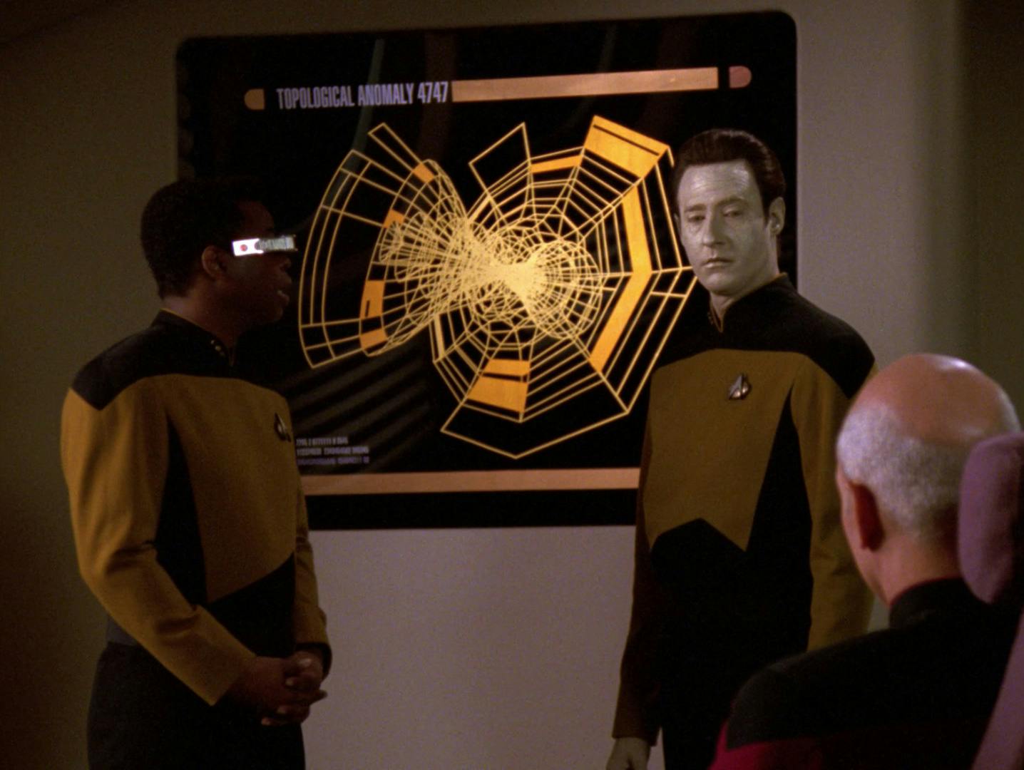 Geordi La Forge and Data stand and present the topological anomaly 4747 to Picard and senior crew members in 'I, Borg'