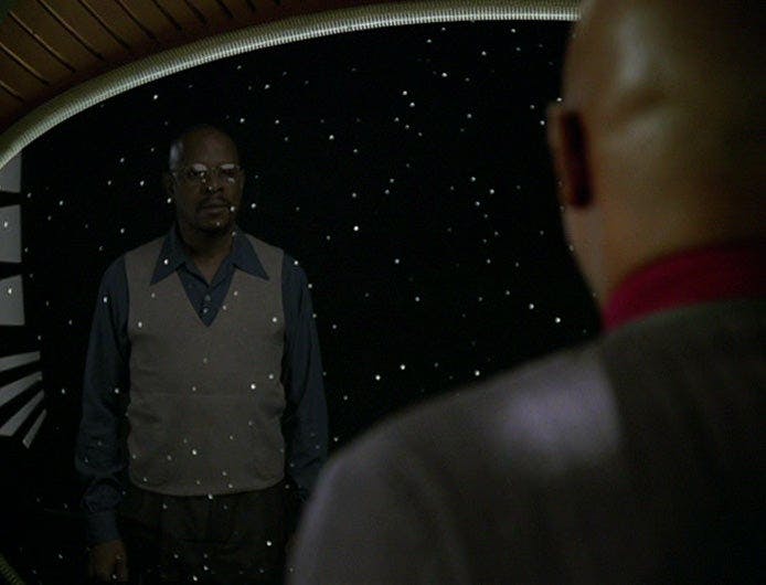 Sisko looks out of his window with his reflection as Benny Russell looks back at him on Star Trek: Deep Space Nine