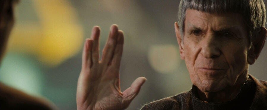 Close-up of Leonard Nimoy's Ambassador Spock lifting his hand in the Vulcan salute towards Zachary Quinto's Spock in Star Trek (2009)
