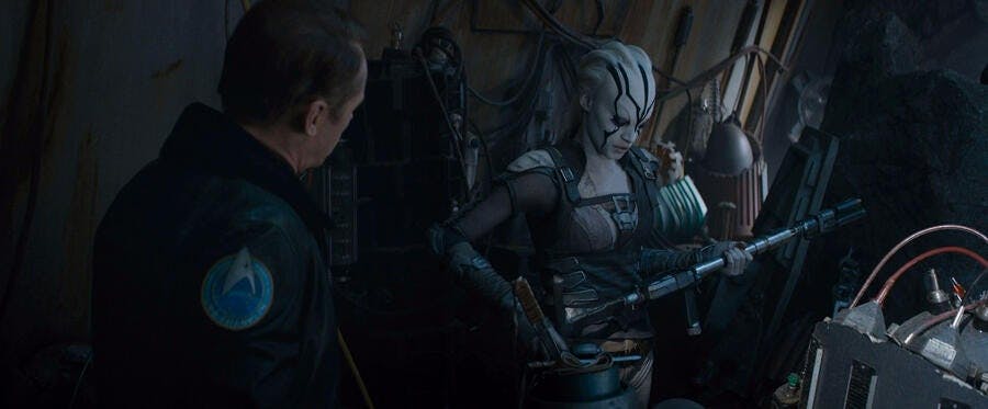 Scotty appeals to Jaylah as she assesses her rifle in Star Trek Beyond