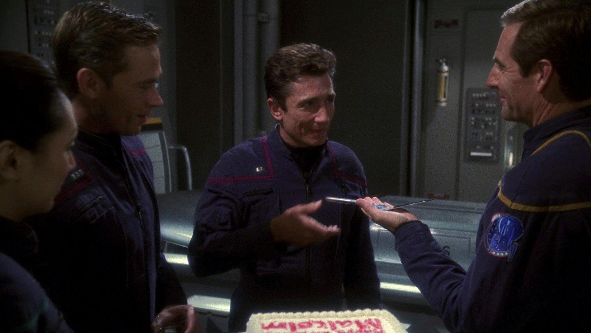 Star Trek: Enterprise - 'Silent Enemy' still of a smiling Archer handing Malcolm a cake serving knife