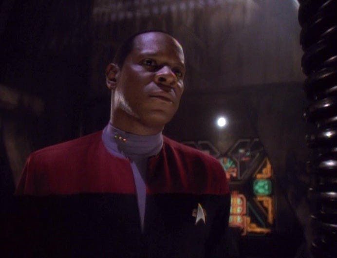 Captain Sisko (Avery Brooks) stands at attention.