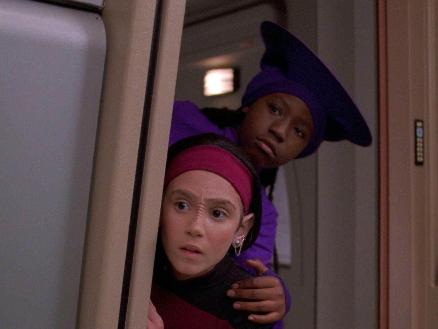 Guinan and Ensign Ro (both in their kid bodies) peek past a doorway in 'Rascals'