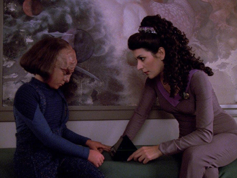 Deanna Troi looks over and comforts a downtrodden Alexander in 'Ethics'