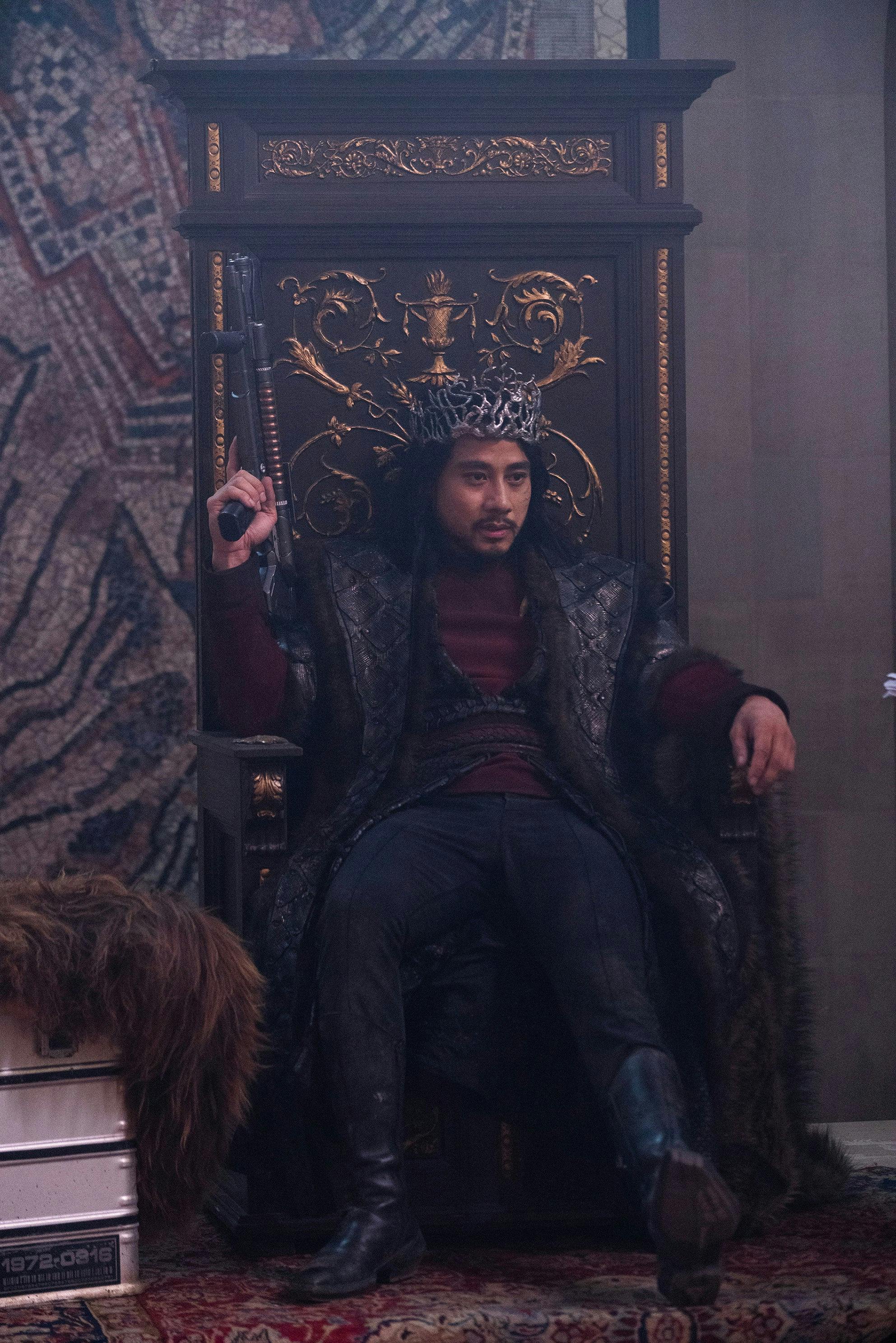 The High Lord of Kalar and Pike's former Yeoman, Zacarias, wearing a stylized crown, sits on the palace throne in 'Among the Lotus Eaters'