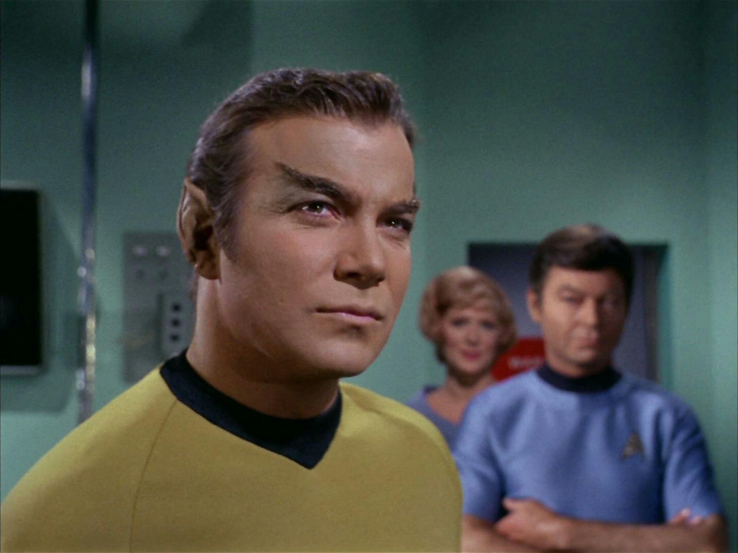 In Sickbay, Nurse Chapel and McCoy look over at Captain Kirk who just underwent a cosmetic surgery to appear Romulan in 'The Enterprise Incident'