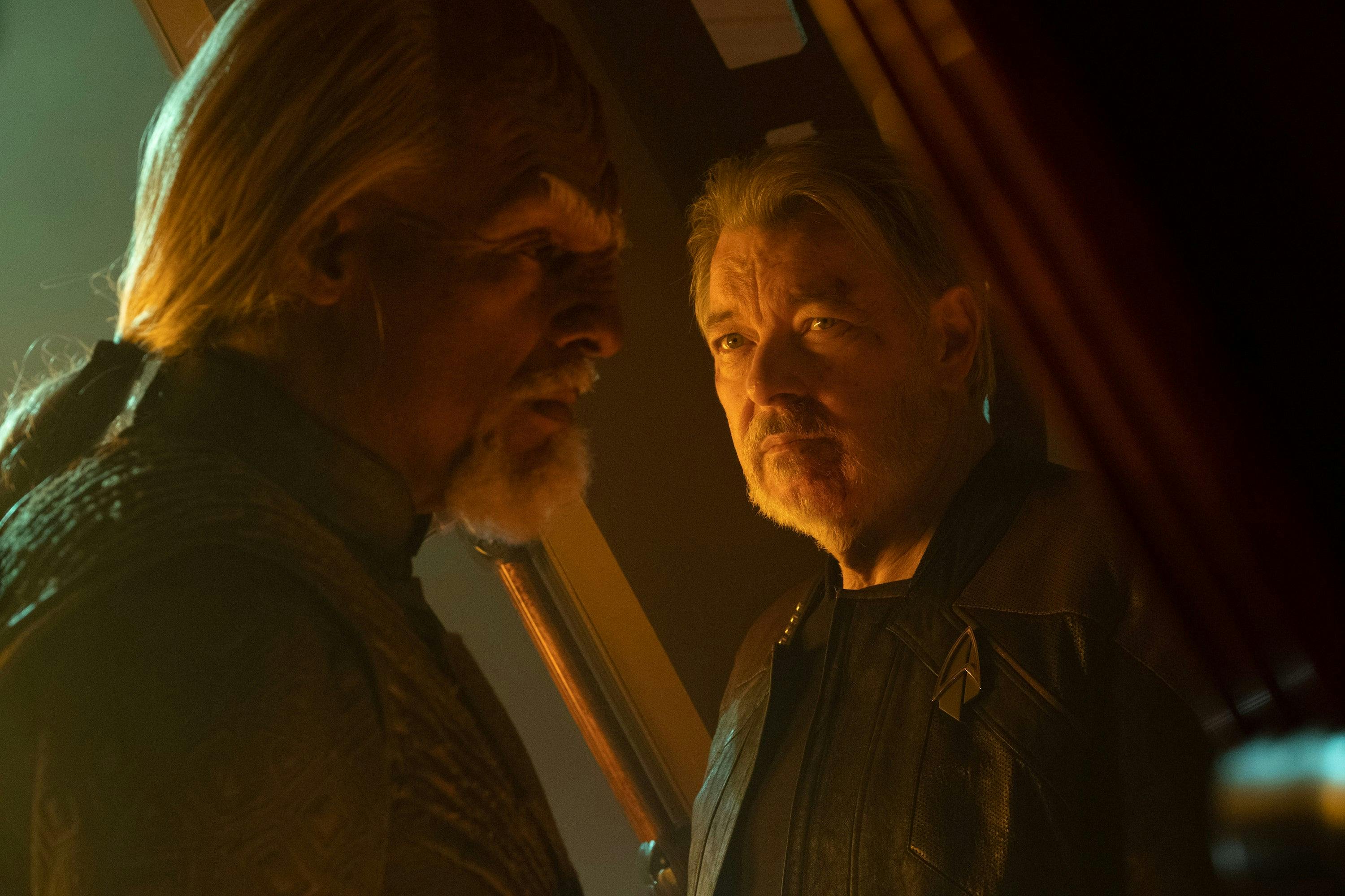 Worf and Riker pass each other as Will turns to look over at his friend on the Shrike