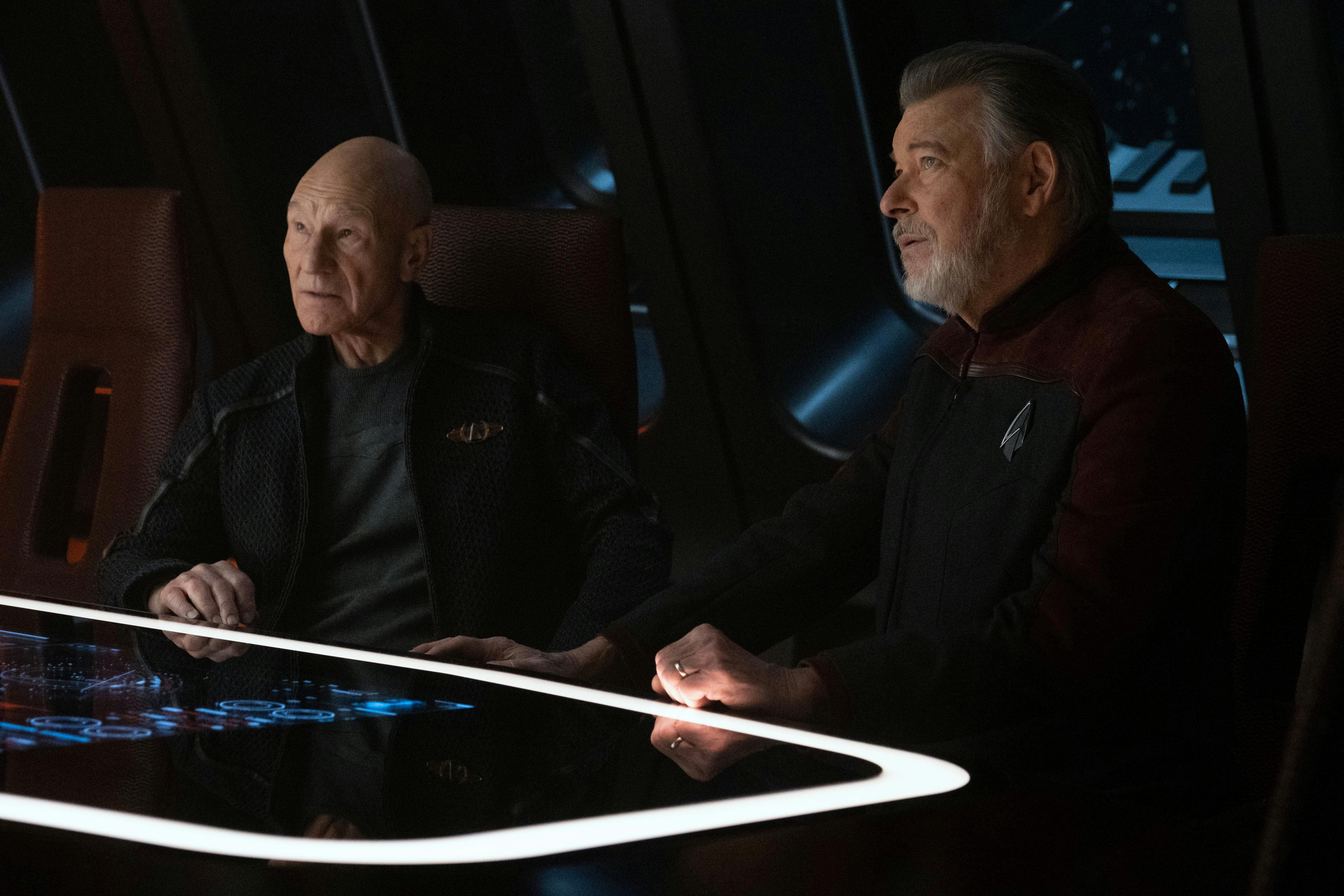 Picard and Riker sit in the Observation Lounge of the Titan and look up and forward