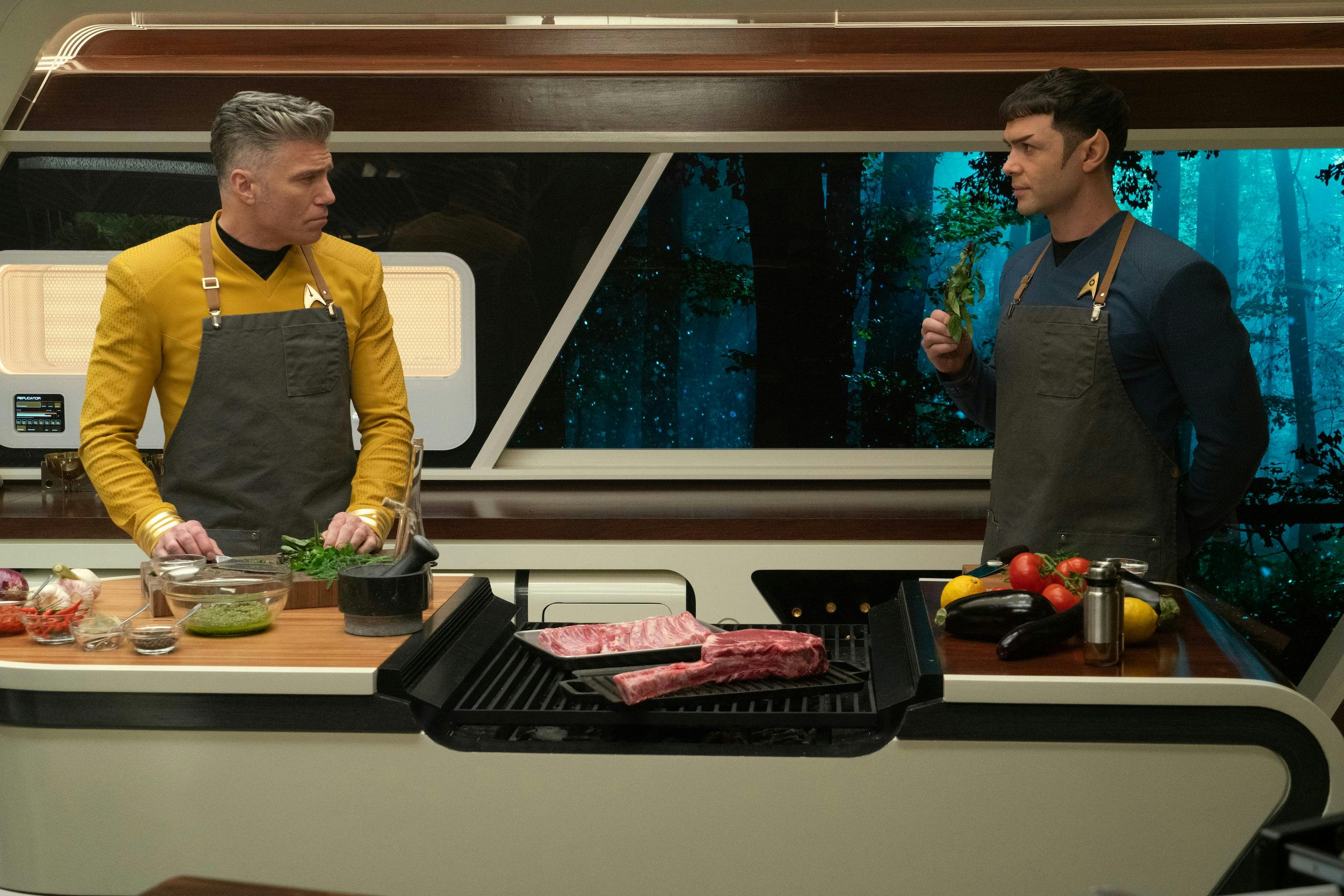 In the captain's quarters, Pike and Spock stand in the kitchen with aprons on preparing a meal in 'Charades'