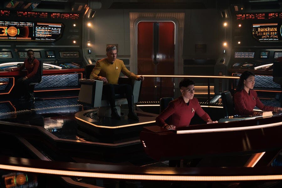 Captain Pike (Anson Mount) sits in the captain's chair of the Enterprise. Cadet Uhura (Celia Rose Gooding) is at a console, and Lt. Ortegas (Melissa Navia) and another crew member are at the helm in 'A Quality of Mercy'