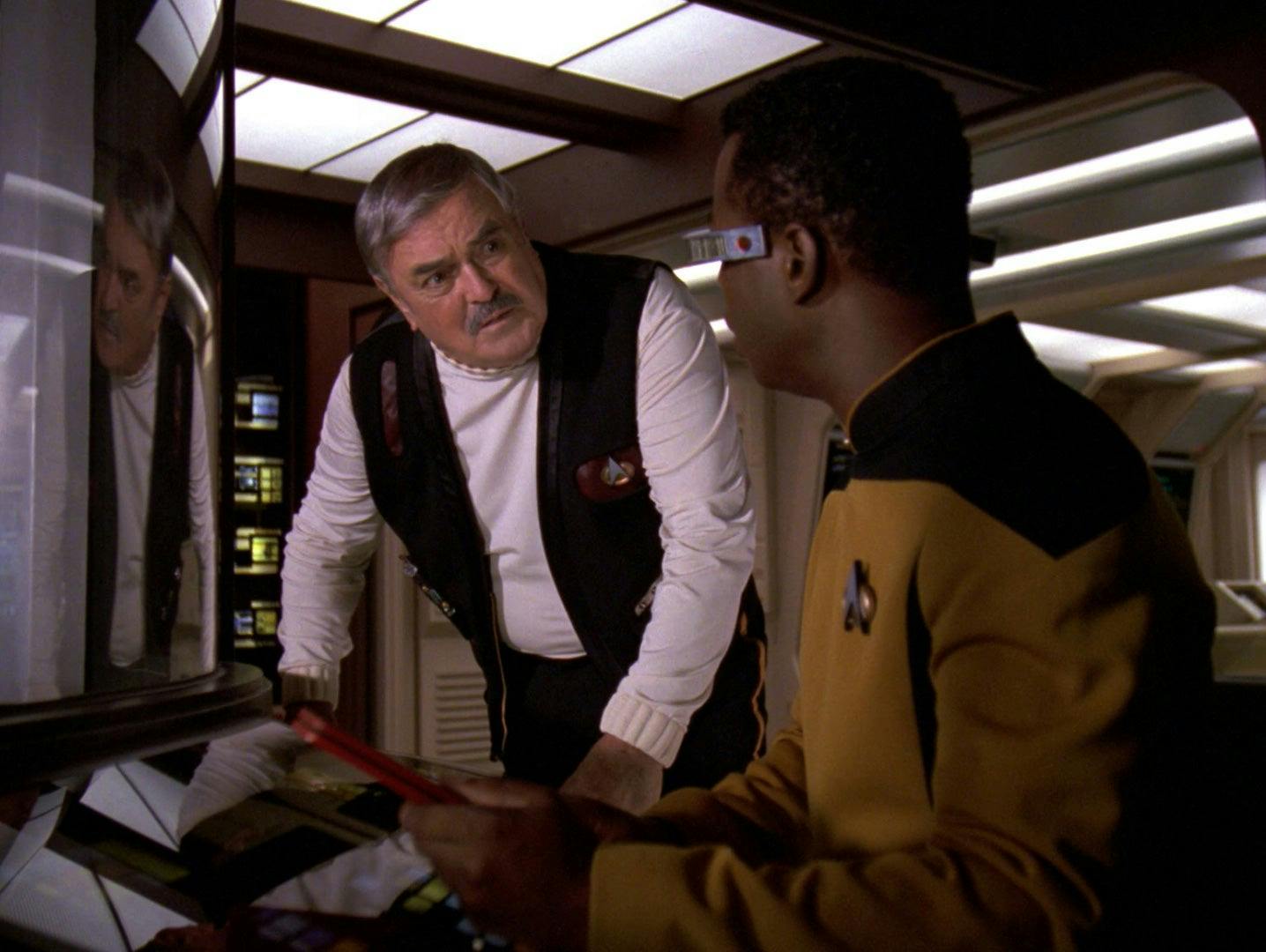 Scotty stands next to Geordi La Forge in engineering aboard the Enterprise-D.