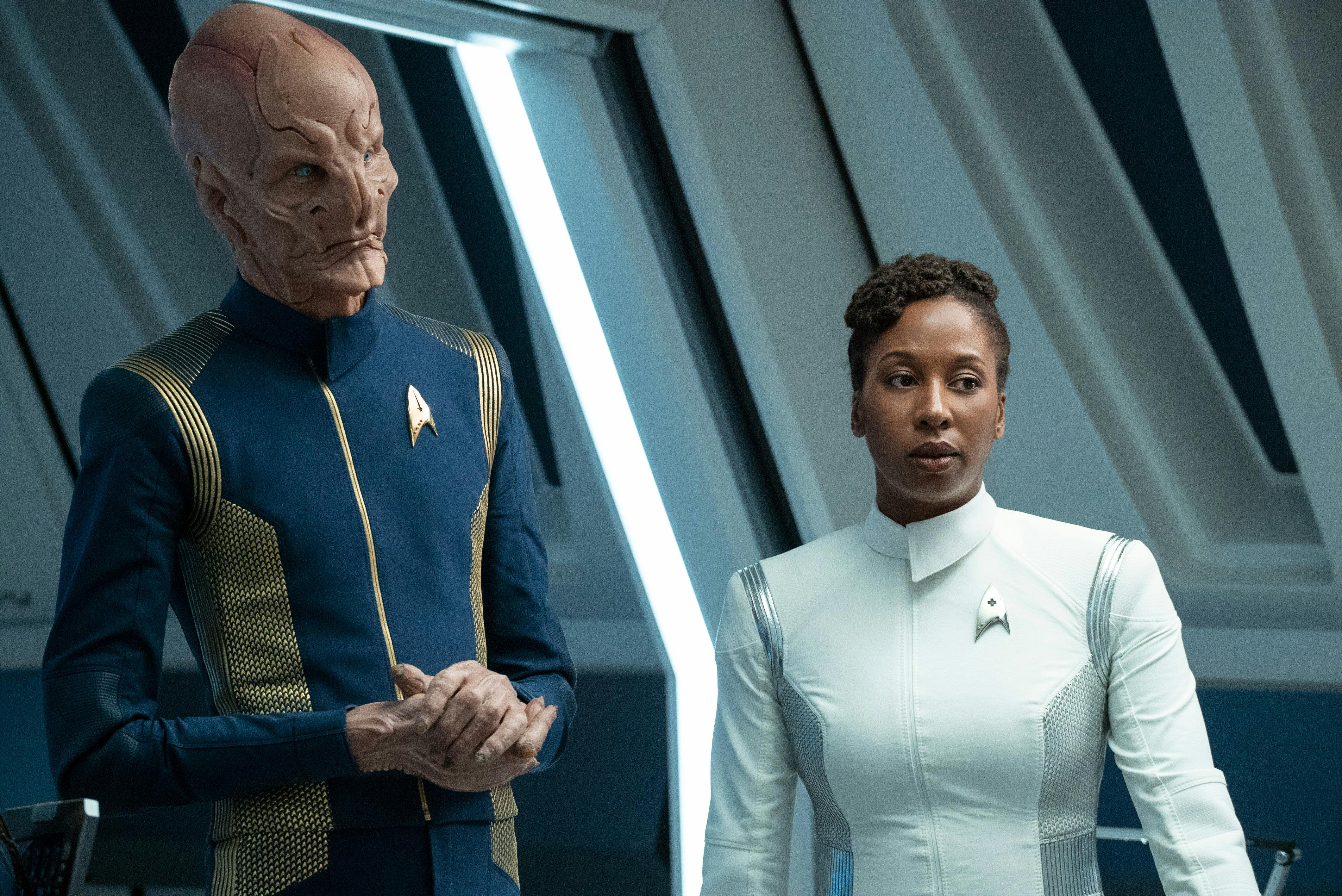 In Sickbay, both Saru and Dr. Tracy Pollard look over at the bio-bed with a look of concern in Star Trek: Discovery's 'Forget Me Not'