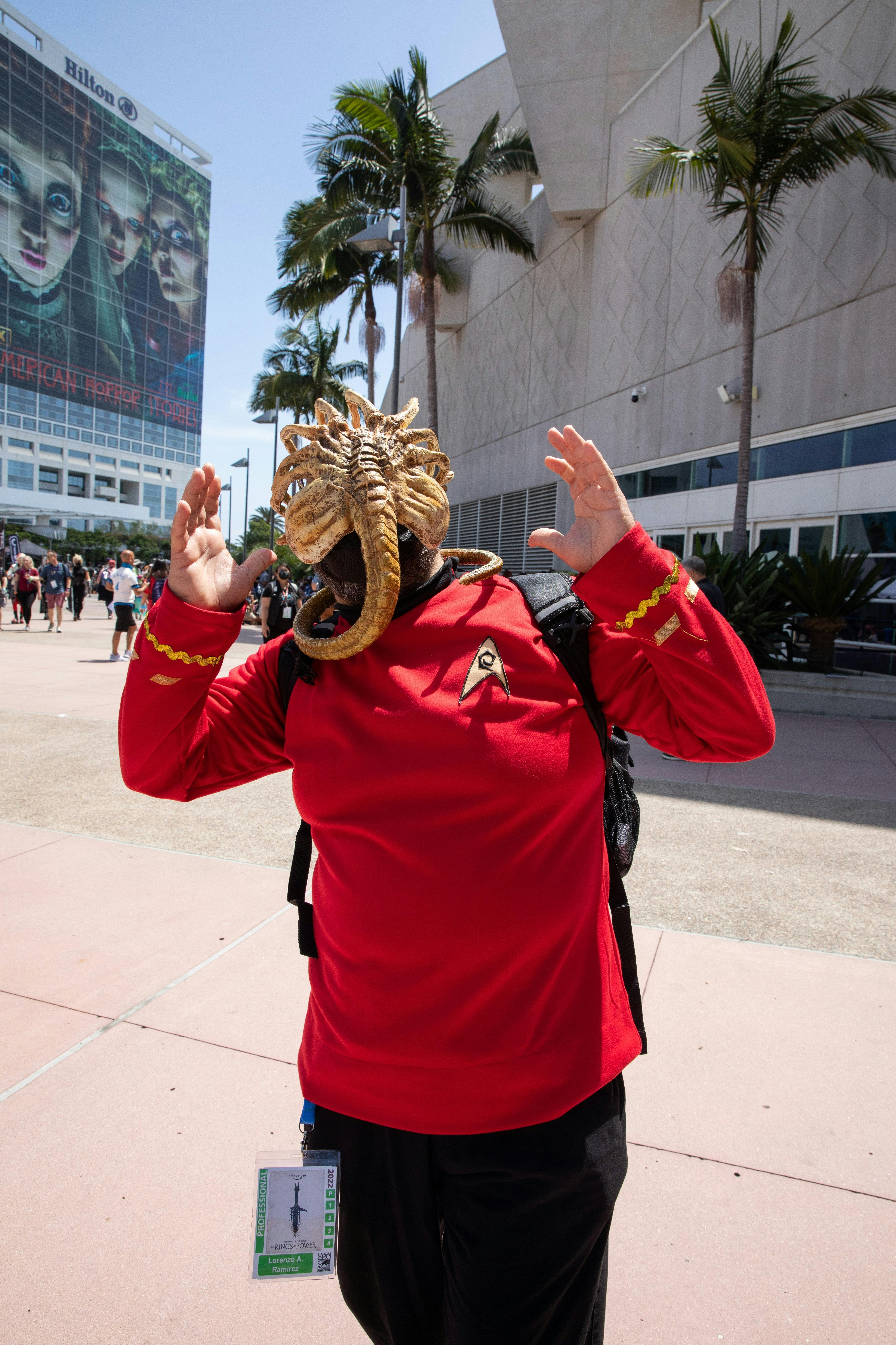 A fan dressed up as a redshirt being attacked by an alien poses for a photo.