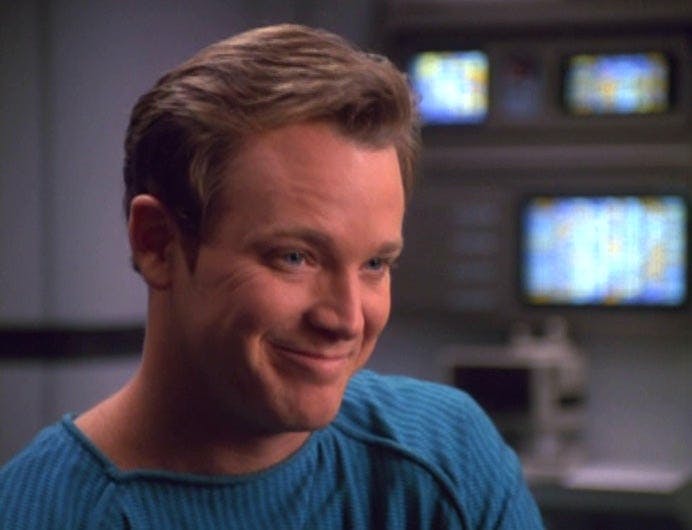 Tom Paris smiles in Sickbay after he's reverted back into his human form on Star Trek: Voyager