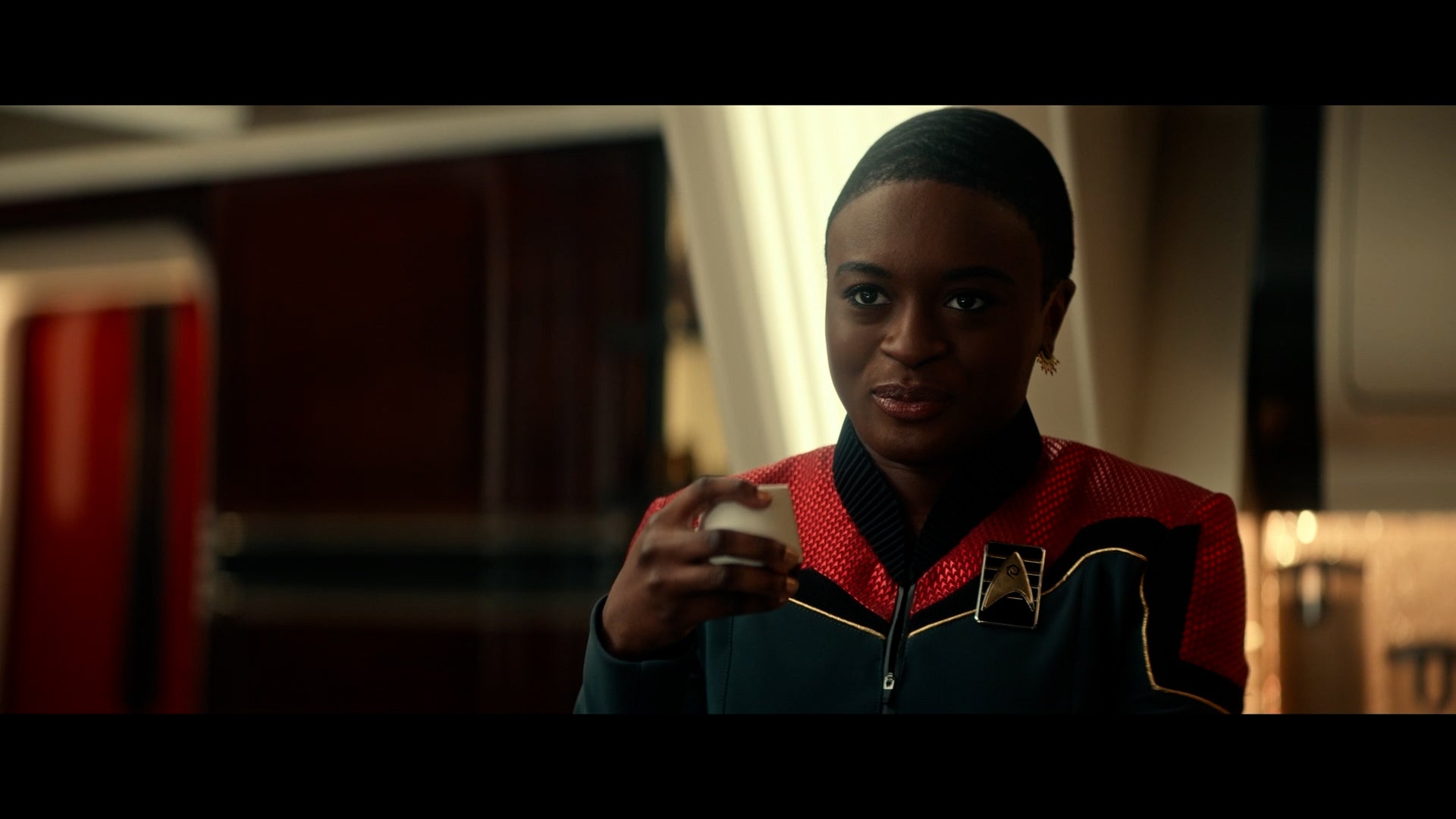 Cadet Uhura holding a glass in her left hand from episode two