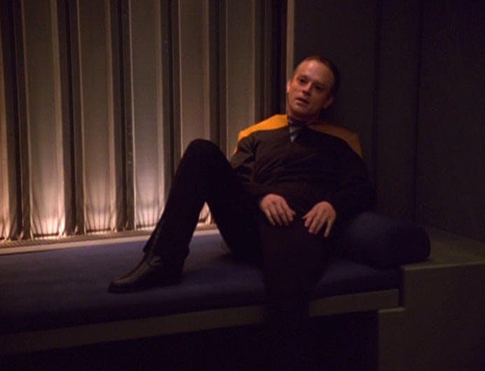 Suder sits in the Brig with one leg bent on Star Trek: Voyager