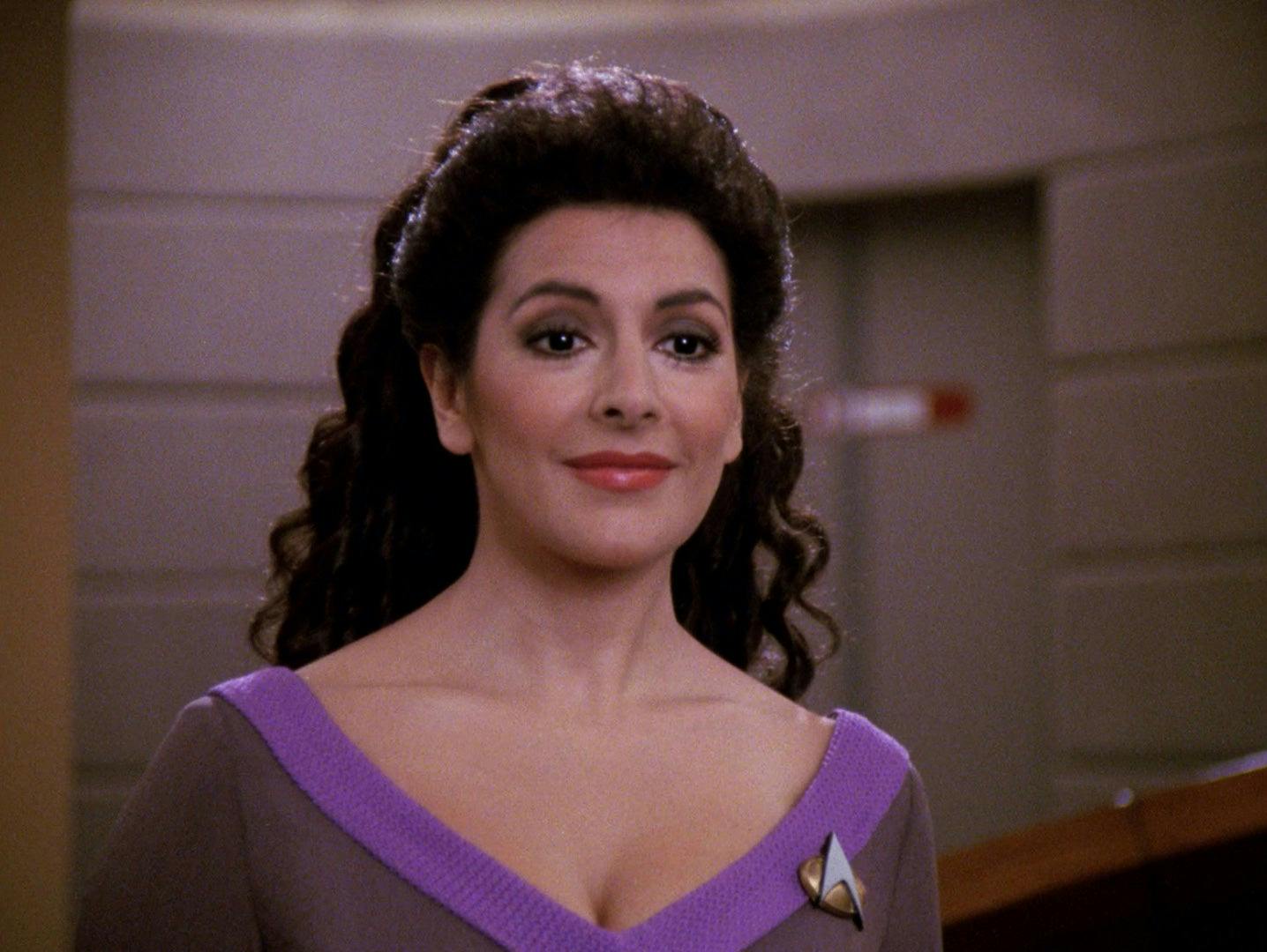 Deanna Troi smiles on the bridge of the Enterprise-D.