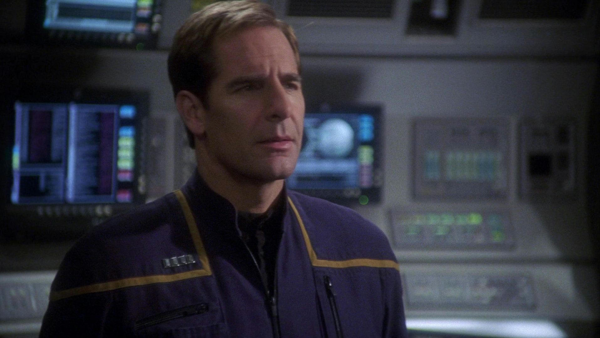 Captain Archer stands on the bridge of the NX-01, looking concerned.