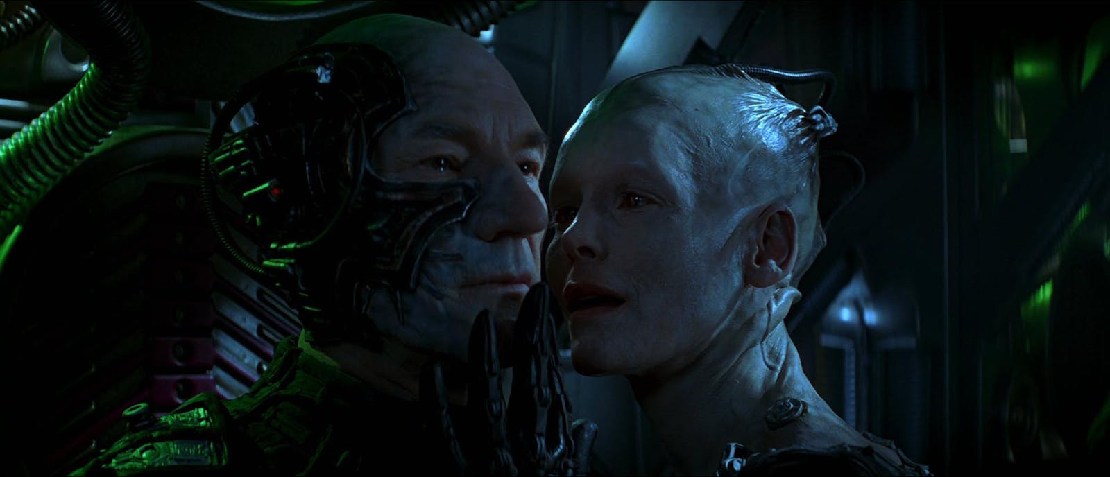 Picard as Locutus of Borg with tears in his eyes as the Borg Queen faces him with her hand touching his face in Star Trek First Contact