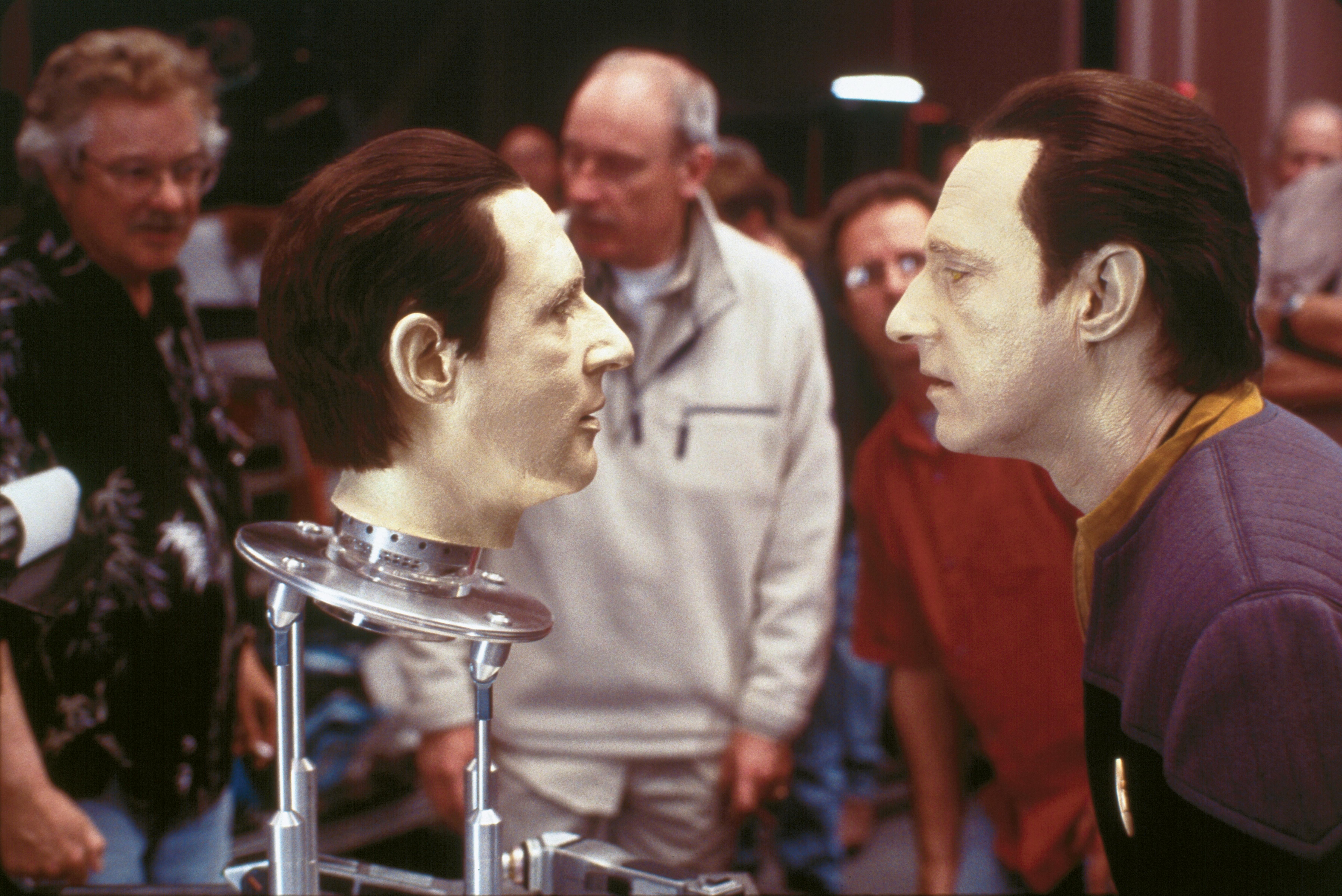 Brent Spiner (right) dressed as Data looking at the head of B-4 as crew look behind them on set of Star Trek Nemesis