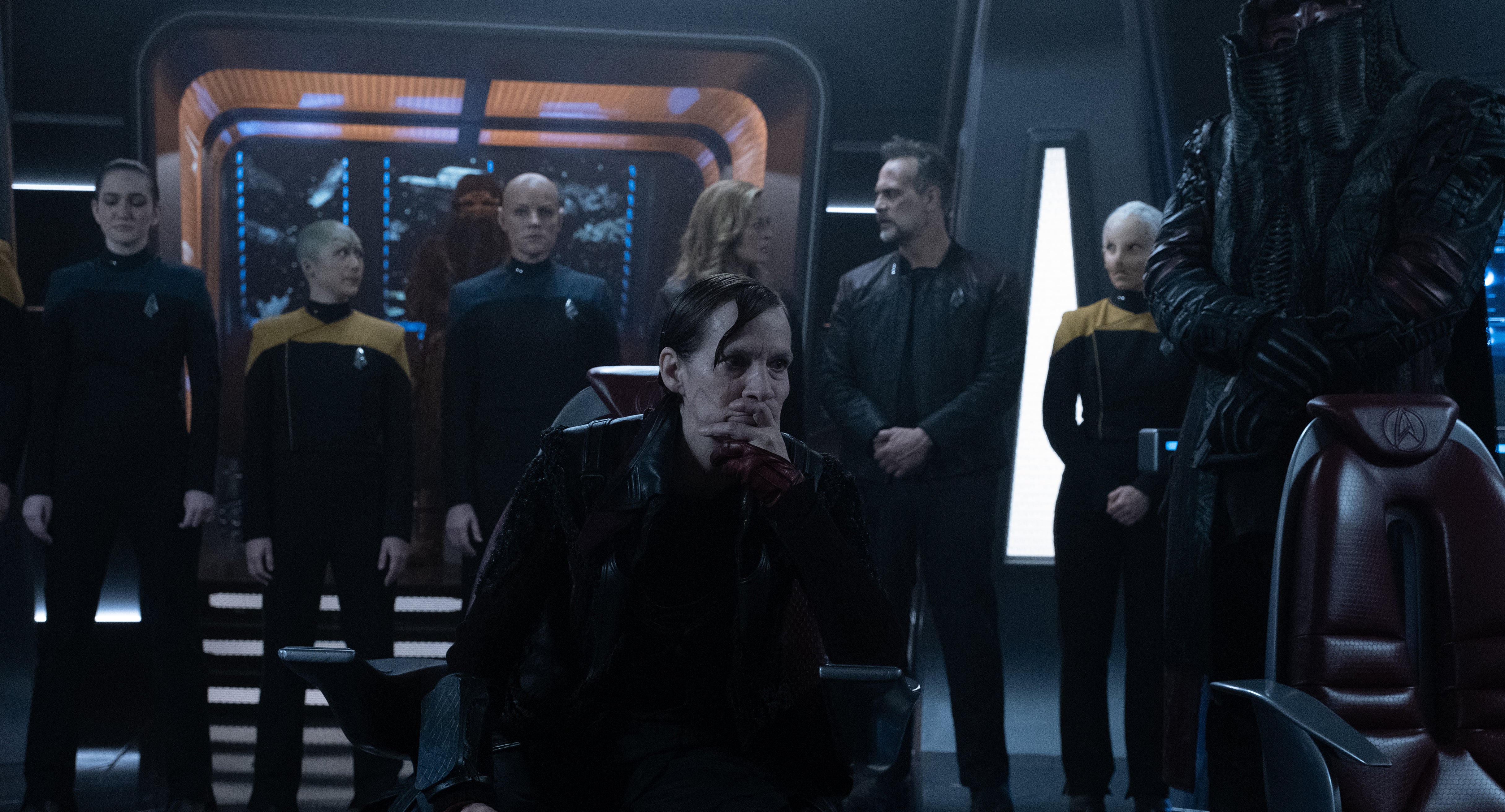 Vadic sits in the Captain's Chair as the Titan's crew is held captive and lined up behind her