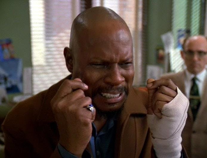 A frustrated Benny Russell (Captain Sisko) breaks down furious and sobbing as Herbert Rossoff (Quark) looks on in the background of Star Trek: Deep Space Nine